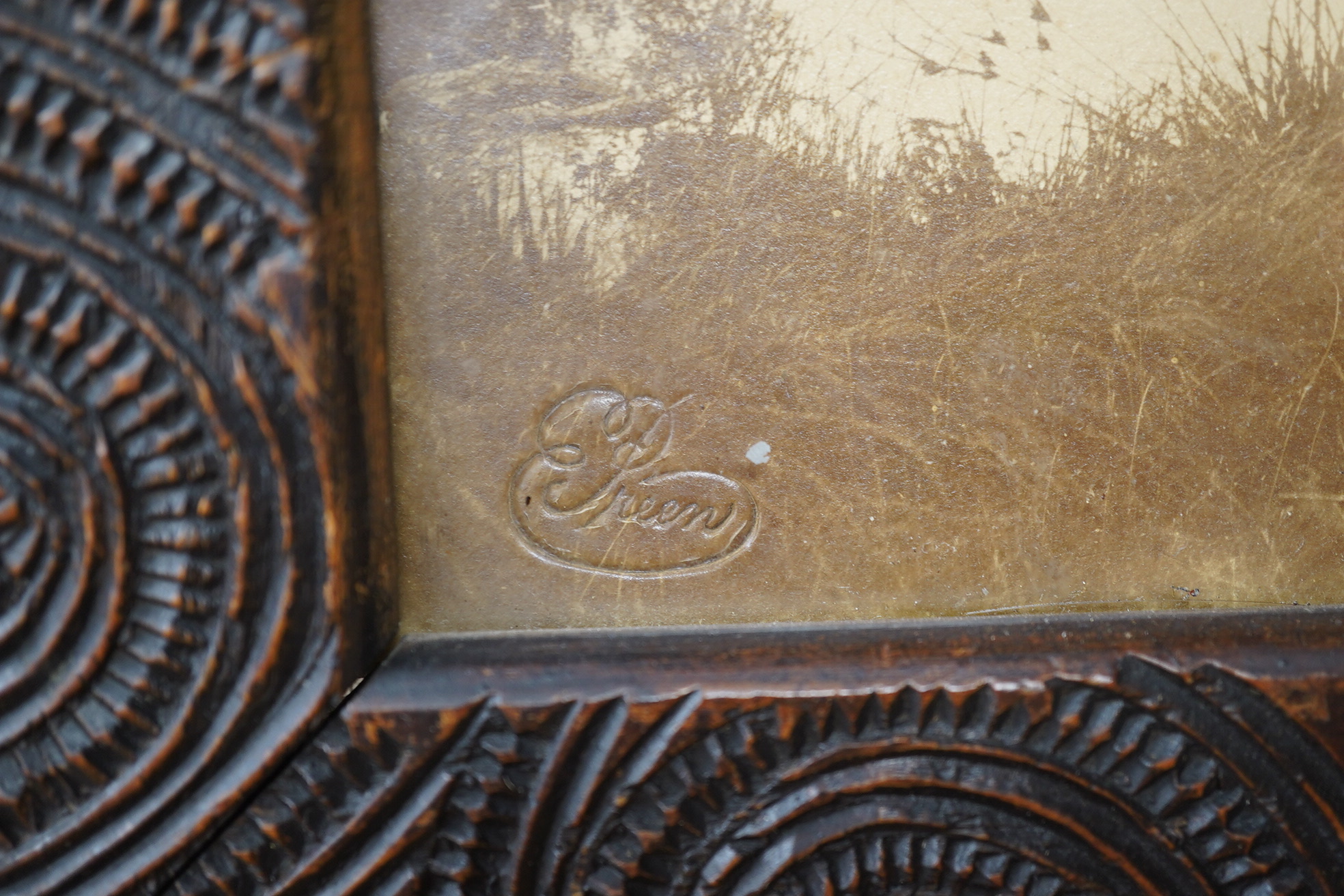 A pair of Maori carved wood photograph frames containing contemporary New Zealand photographs c.1900-10, carved in relief with rauponga lines and spirals, inset with contemporary albumen photos, depicting figures by Waik